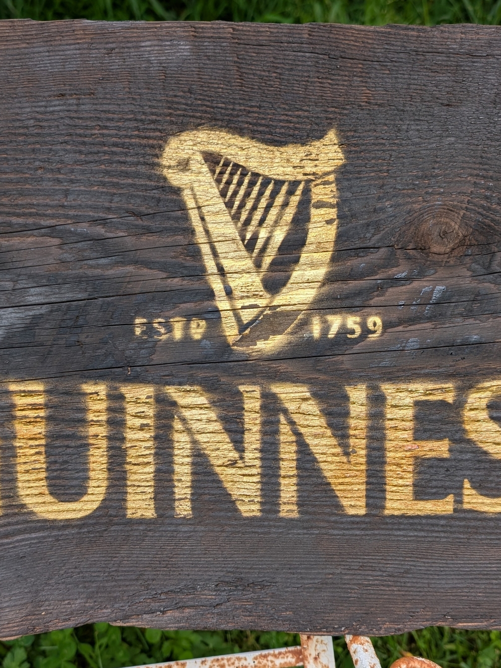 Guinness Gold Harp and Lettering on Dark Wood